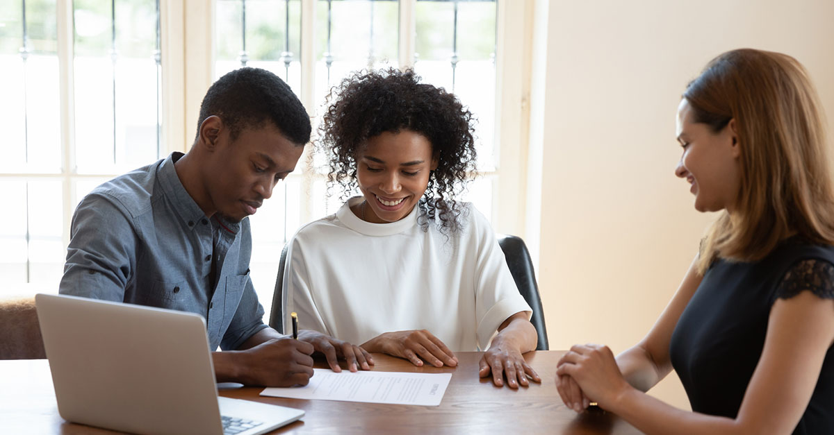 A couple signing documents with their closer